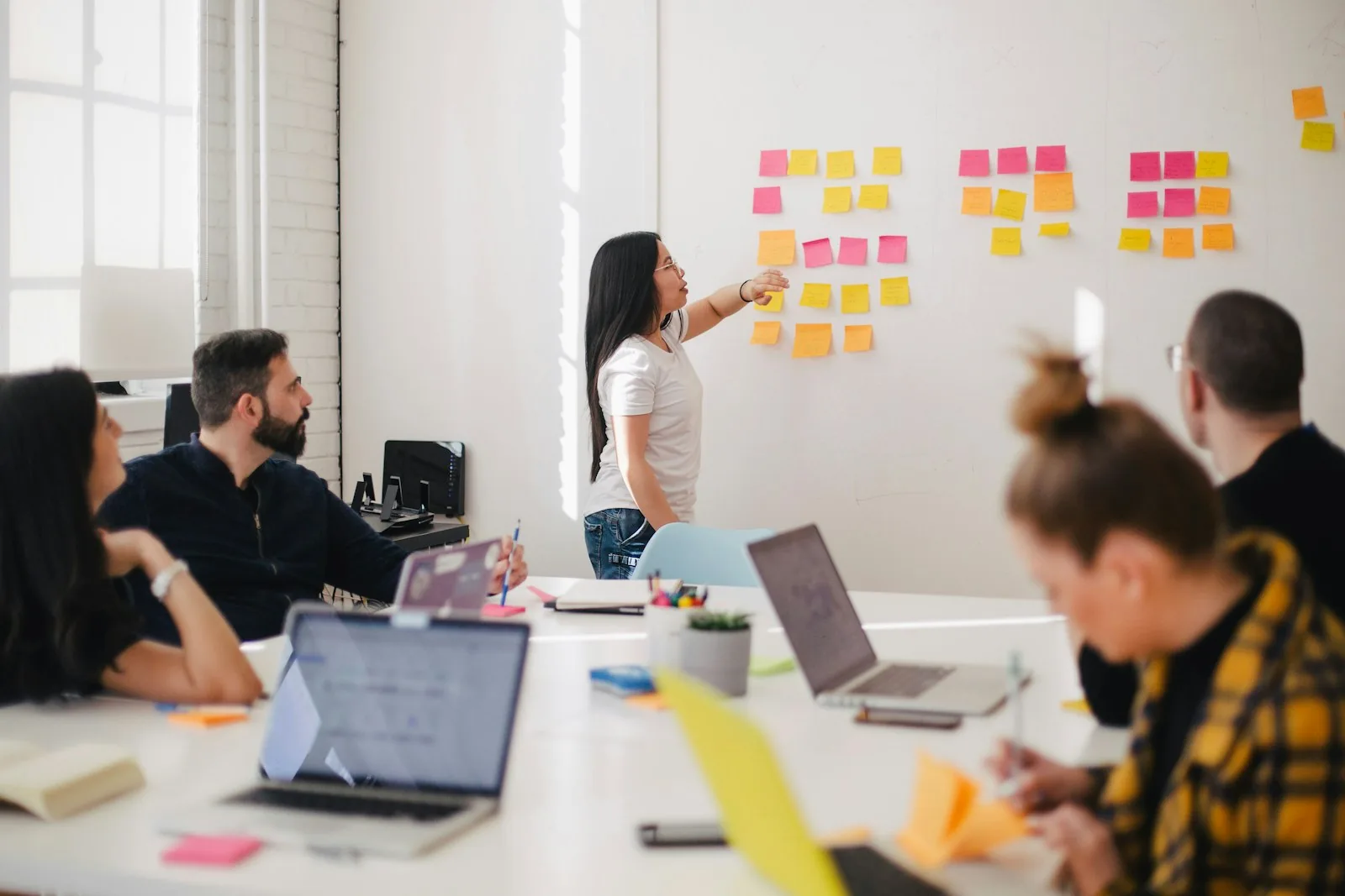 A team planning a project together at a whiteboard of sticky notes