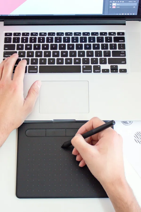 A designer sketching on a drawing tablet